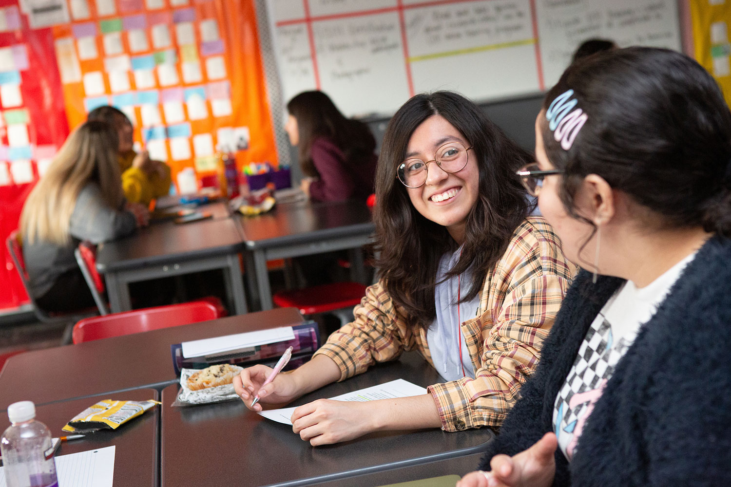 Two students in a classroom working on a project together